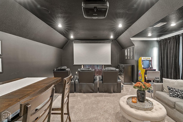 cinema room featuring lofted ceiling, carpet, a textured ceiling, and visible vents