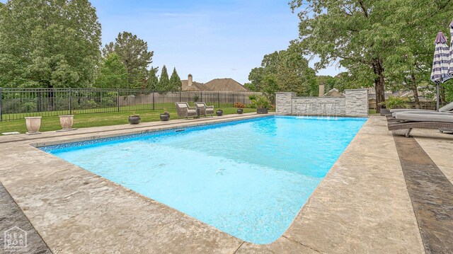 view of pool with a lawn, a patio area, a fenced in pool, and fence