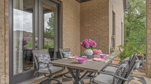 balcony with outdoor dining area and a patio area