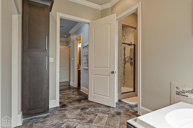 bathroom with a shower stall, baseboards, and crown molding