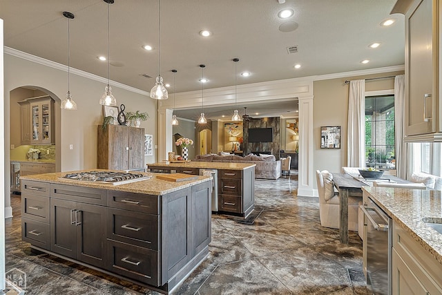 kitchen with a center island, marble finish floor, crown molding, arched walkways, and stainless steel appliances