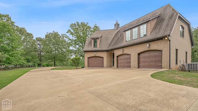 view of side of home with central AC, driveway, brick siding, and a garage
