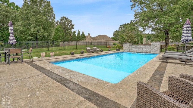 view of pool featuring a lawn, a patio area, a fenced in pool, and a fenced backyard