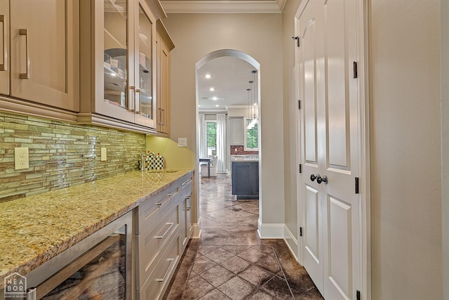 bar with arched walkways, backsplash, ornamental molding, and a sink