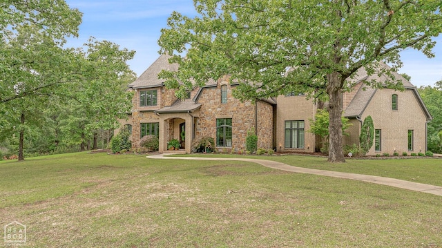 view of front of property featuring stone siding and a front lawn