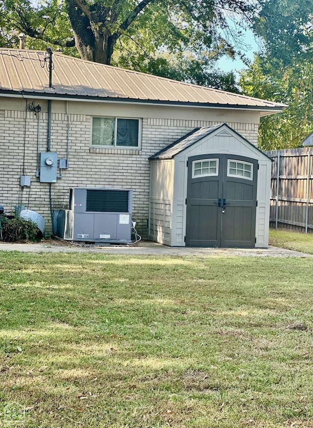 view of shed with central air condition unit and fence