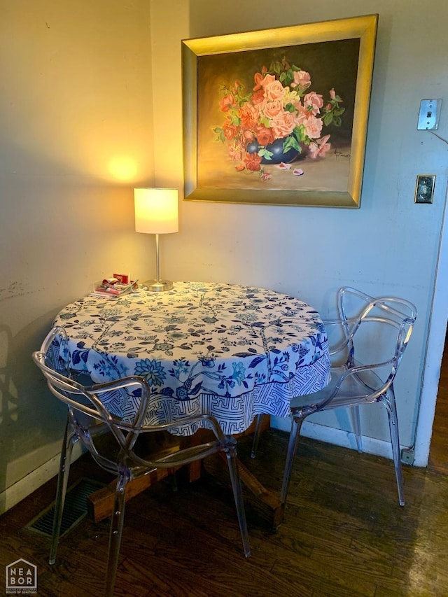 dining space featuring wood finished floors and baseboards
