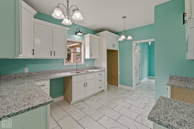 615 W Main St W, Trumann, AR 72472 - kitchen featuring a chandelier, a sink, light marble finish flooring, and pendant lighting