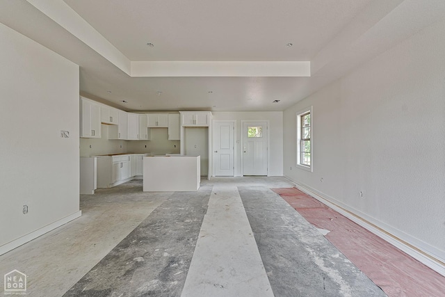 305 Carol Ave, Monette, AR 72447 - unfurnished living room with a raised ceiling and baseboards