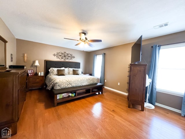 bedroom featuring wood finished floors, baseboards, and a ceiling fan
