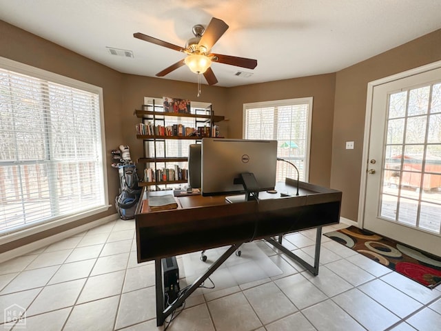 office space featuring plenty of natural light, ceiling fan, and light tile patterned floors