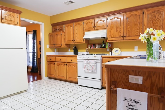kitchen with white appliances, under cabinet range hood, light countertops, a sink, and brown cabinetry