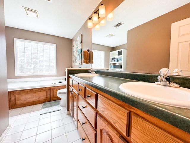 bathroom with double vanity, a bath, tile patterned floors, and toilet