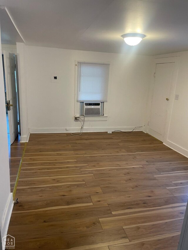 1007 Warren St, Jonesboro, AR 72401 - empty room with baseboards, cooling unit, and wood finished floors