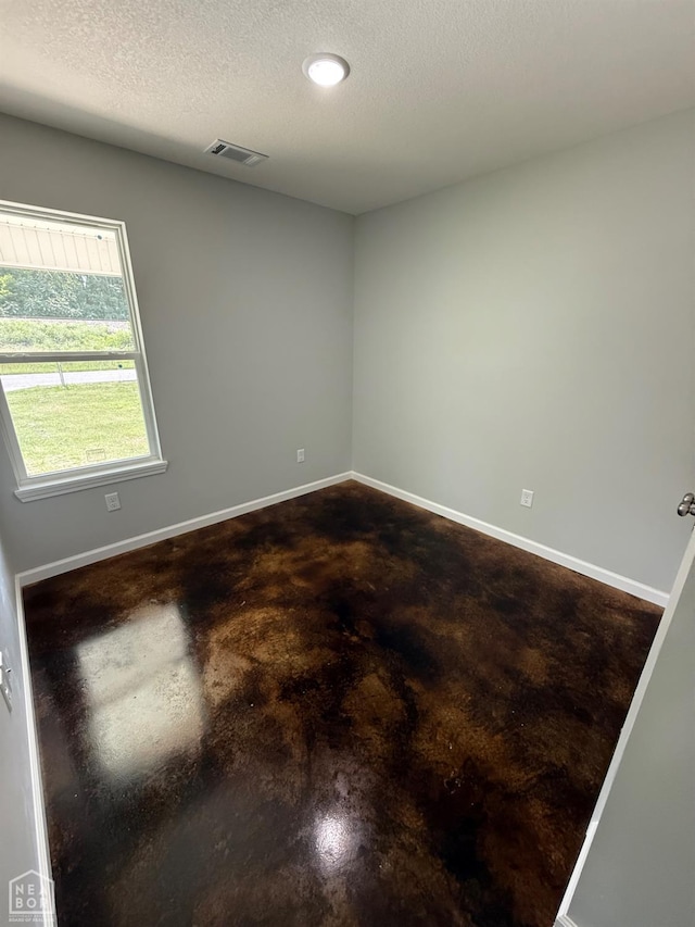 704 N Ozark St, Trumann, AR 72472 - empty room featuring concrete floors, a textured ceiling, and recessed lighting