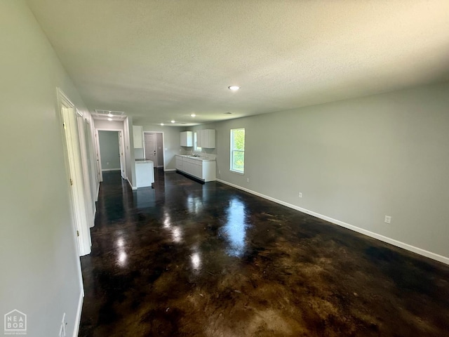 704 N Ozark St, Trumann, AR 72472 - unfurnished living room featuring concrete floors, a textured ceiling, and recessed lighting