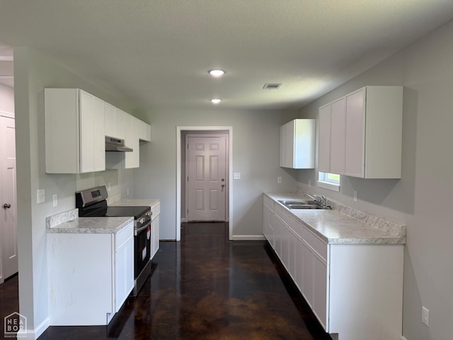 704 N Ozark St, Trumann, AR 72472 - kitchen with stainless steel electric range oven, light countertops, white cabinets, under cabinet range hood, and concrete flooring