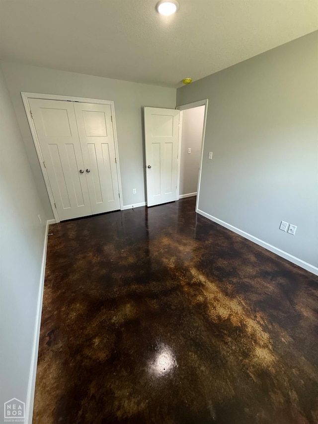 704 N Ozark St, Trumann, AR 72472 - unfurnished bedroom featuring concrete flooring and a closet