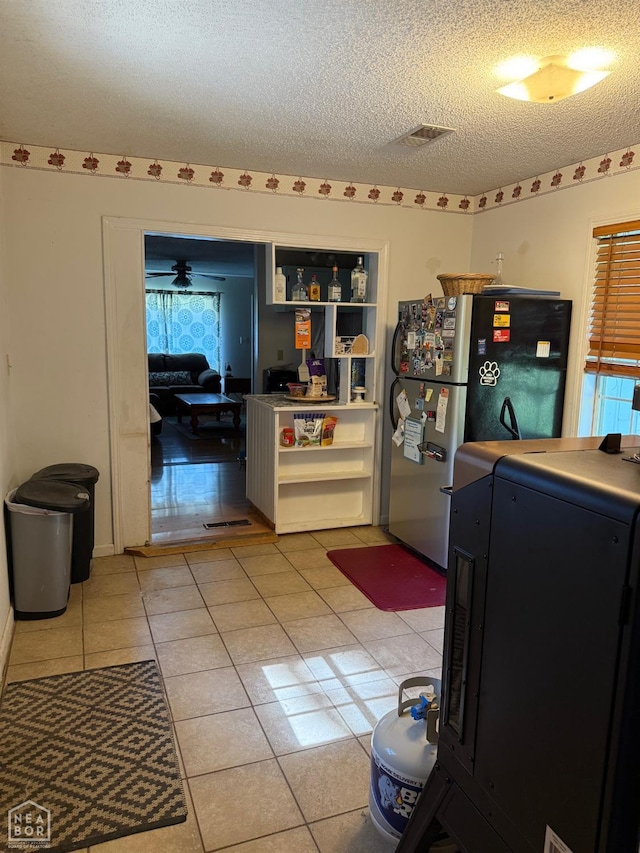 1304 Dana Debbie St, Jonesboro, AR 72405 - kitchen featuring freestanding refrigerator, open shelves, a textured ceiling, light tile patterned flooring, and washer / dryer