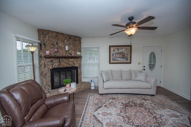 1123 Olive St, Jonesboro, AR 72401 - living area featuring a ceiling fan, wood finished floors, a stone fireplace, and baseboards