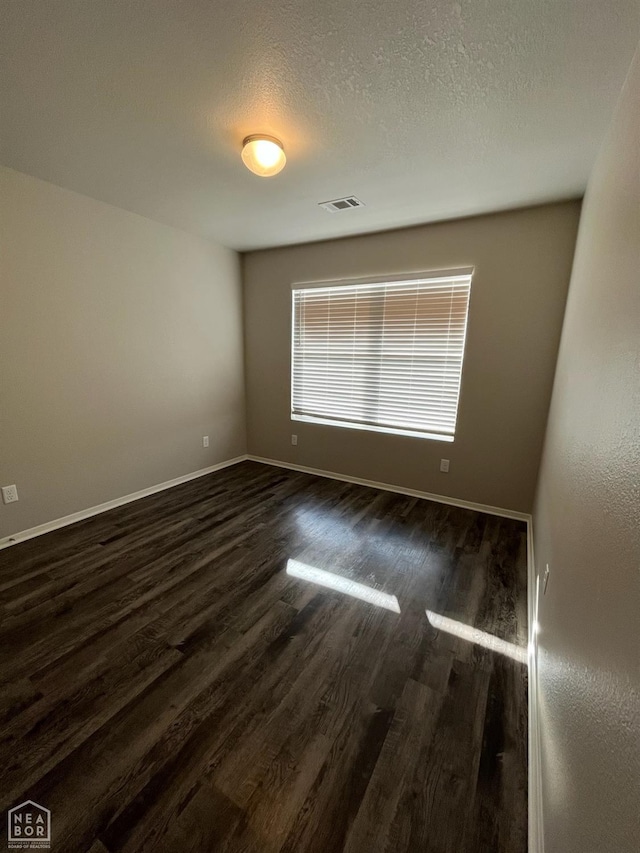3804 Glitterman Dr, Jonesboro, AR 72404 - unfurnished room with dark wood-style floors, baseboards, and a textured ceiling