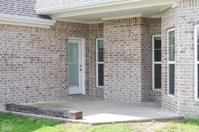 113 Hidden Creek Dr, Brookland, AR 72417 - doorway to property with a patio area, brick siding, and a shingled roof