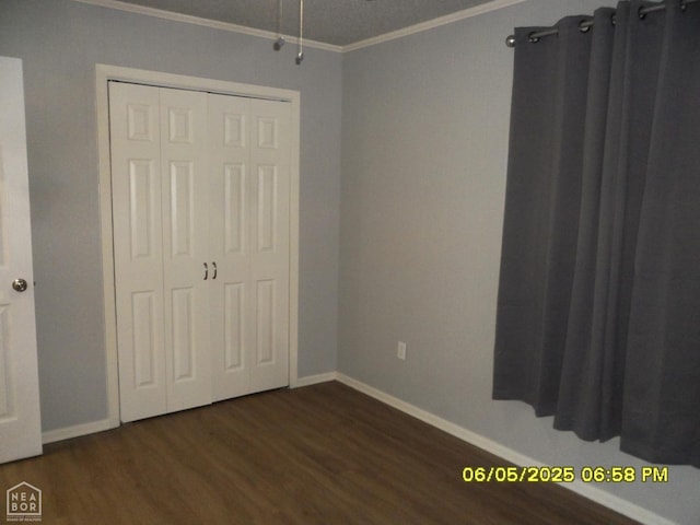 404 Logan St, Newport, AR 72112 - unfurnished bedroom featuring ornamental molding, dark wood-style flooring, baseboards, and a closet