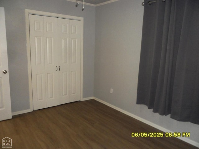 404 Logan St, Newport, AR 72112 - unfurnished bedroom featuring baseboards, dark wood-type flooring, a closet, and ornamental molding