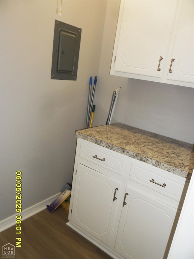 404 Logan St, Newport, AR 72112 - kitchen with electric panel, dark wood finished floors, white cabinets, and baseboards
