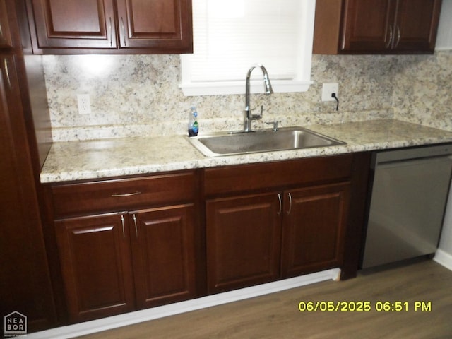 404 Logan St, Newport, AR 72112 - kitchen featuring a sink, dishwasher, backsplash, light stone countertops, and wood finished floors