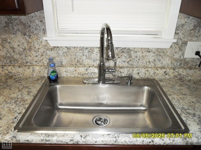 404 Logan St, Newport, AR 72112 - kitchen view of a sink, tasteful backsplash, and light stone counters