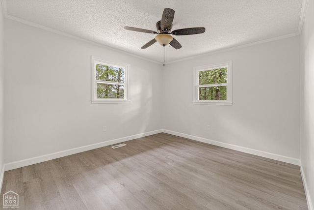 spare room featuring plenty of natural light, visible vents, and a textured ceiling