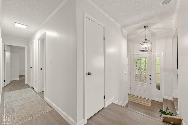 foyer featuring a notable chandelier, a textured ceiling, and wood finished floors
