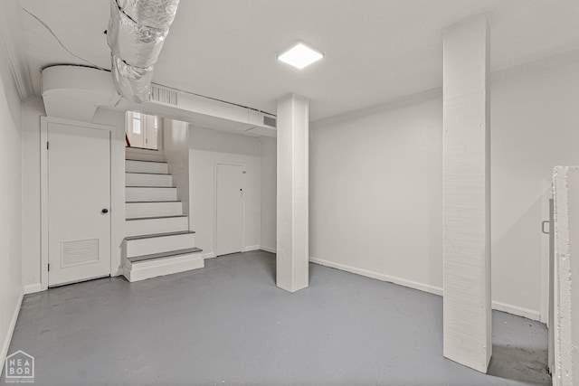 finished basement with stairs, baseboards, and visible vents