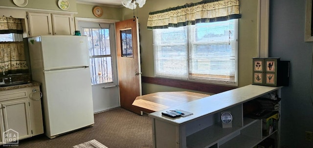 kitchen featuring plenty of natural light, freestanding refrigerator, and dark carpet