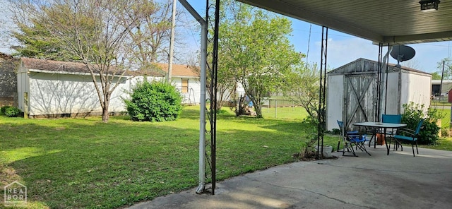 view of yard with an outbuilding, a patio, and a shed