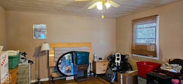 interior space with a ceiling fan, ornamental molding, and wood finished floors