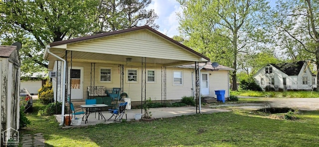 rear view of house with a yard and a patio