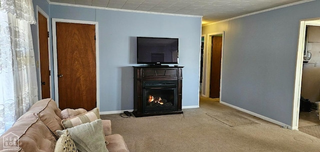 carpeted living area with a warm lit fireplace, crown molding, and baseboards