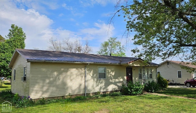 exterior space featuring a front lawn and metal roof