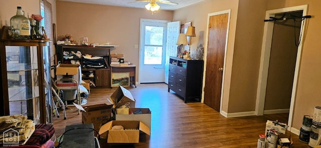 interior space with baseboards, a ceiling fan, and wood finished floors