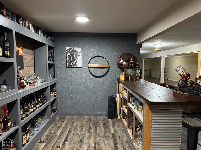 13534 Mc 8001, Yellville, AR 72687 - wine room with a bar, wood finished floors, a textured wall, and baseboards