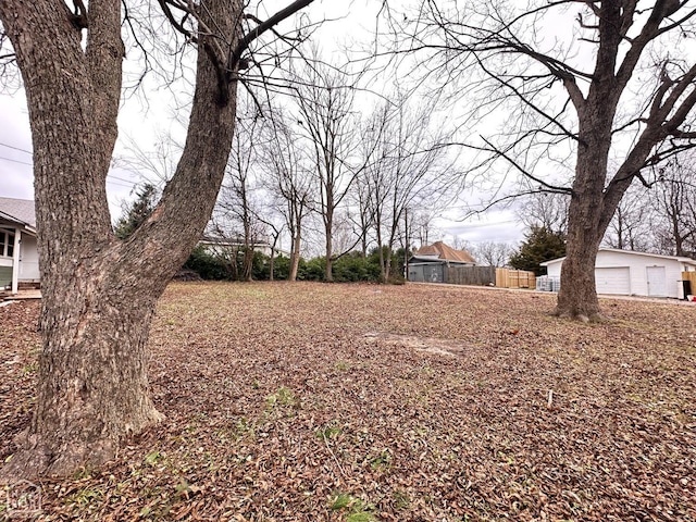 view of yard featuring fence and a garage