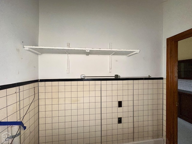 bathroom featuring wainscoting and tile walls