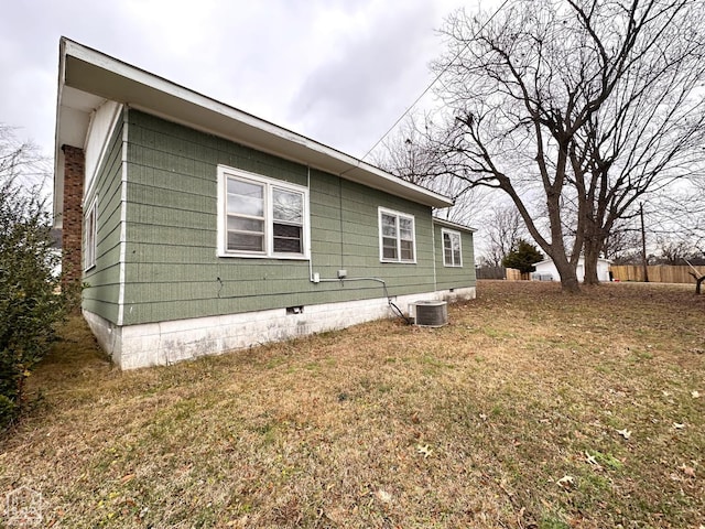 view of side of home with crawl space, central air condition unit, and a lawn