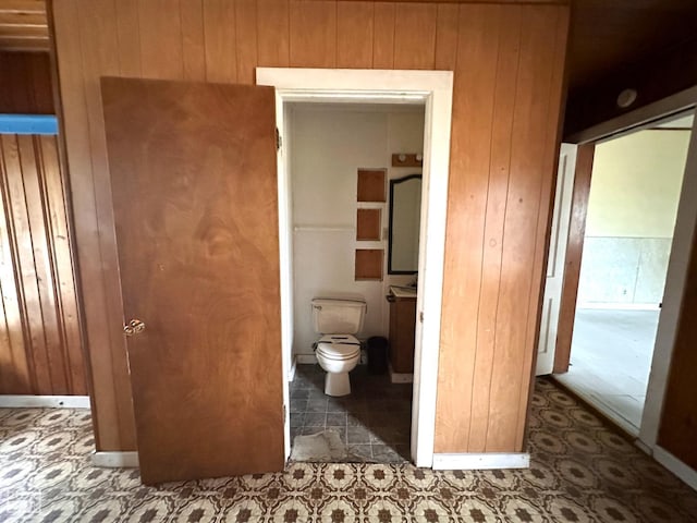 bathroom with toilet and wooden walls