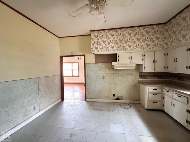 kitchen featuring white cabinets, wainscoting, ornamental molding, and ceiling fan