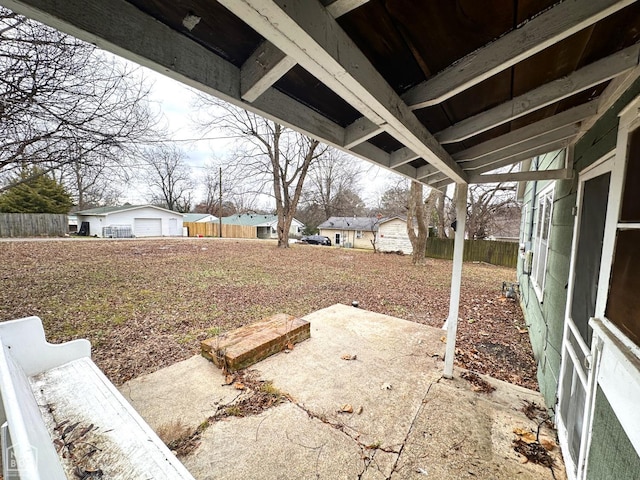 view of yard featuring a garage, fence, and a patio area