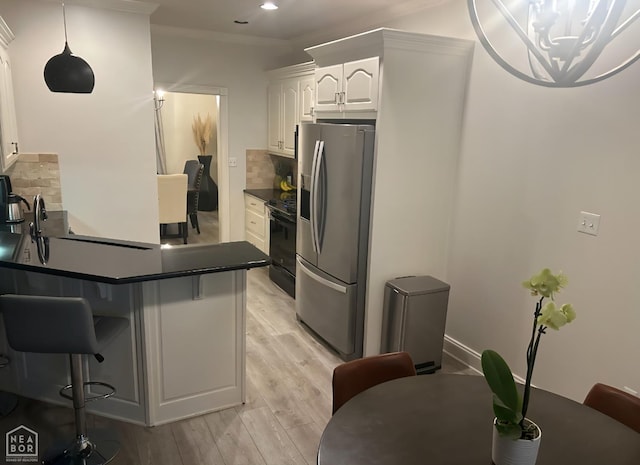 3305 Winged Foot Cv, Jonesboro, AR 72405 - kitchen featuring stainless steel refrigerator with ice dispenser, dark countertops, stove, light wood finished floors, and white cabinets