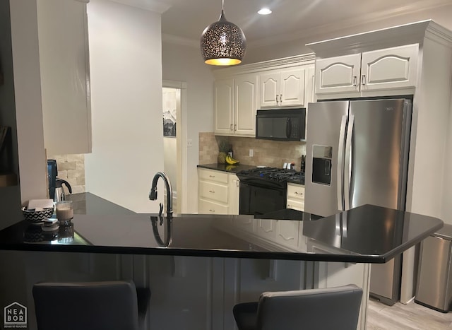3305 Winged Foot Cv, Jonesboro, AR 72405 - kitchen with black appliances, dark countertops, a peninsula, a breakfast bar, and backsplash